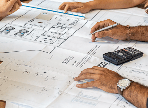 Architects with papers and calculator in front of them on desk