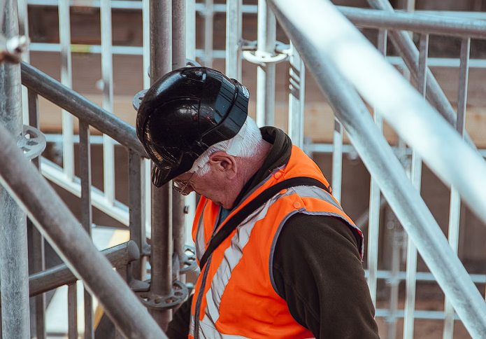 Construction worker with black helmet and orange vest