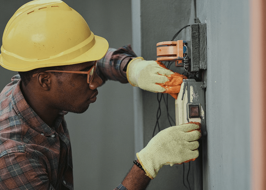 Electrician working with gloves and yellow helmet