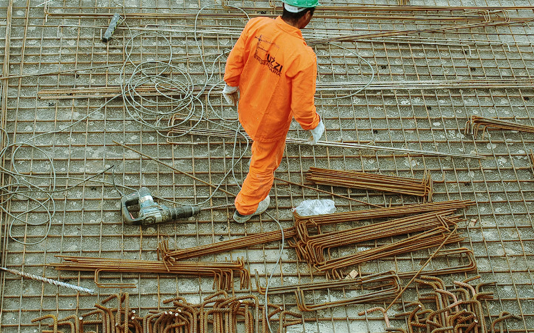 Construction worker on a construction site wearing orange suit