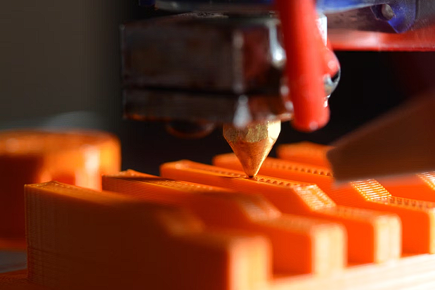 3d printer printing orange object